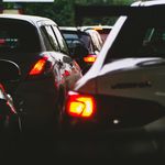 A close-up view of a traffic jam showcasing rear car lights glowing at dusk.